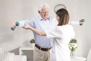 Physical Therapist working with patient holding weights